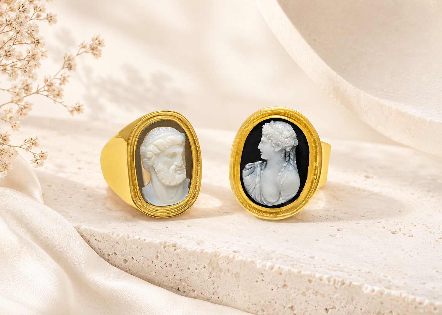 Two antique gold cameo rings with carved classical portrait profiles, displayed on a soft ivory editorial background for DSF Antique Jewelry press coverage.