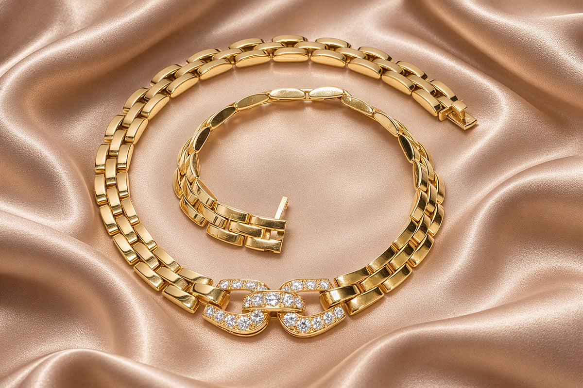 Cartier Panthère Maillon necklace in 18K yellow gold with diamond-set links, displayed on champagne silk.