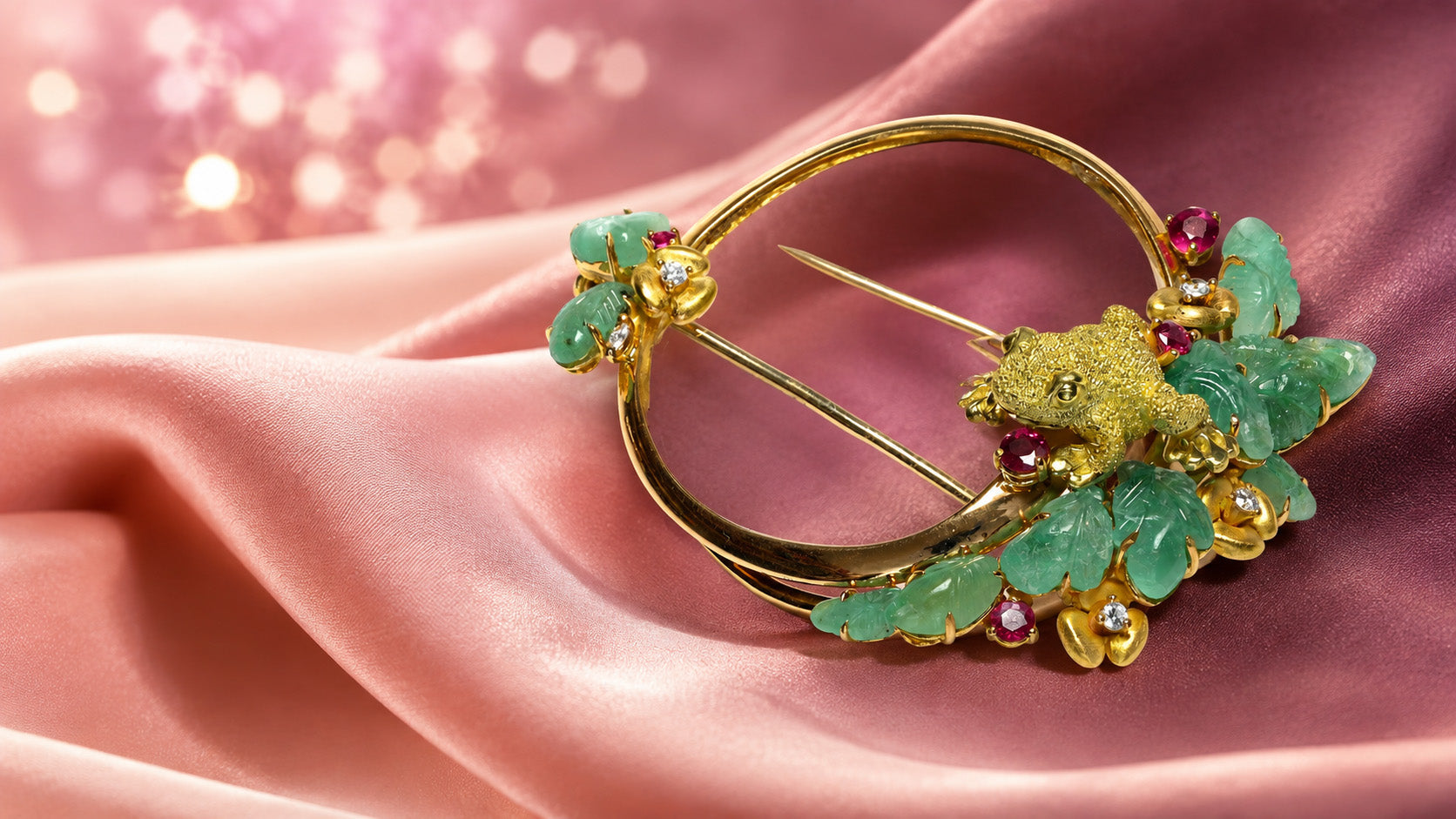 18k gold frog brooch with carved emerald leaves, rubies and diamonds on blush satin.