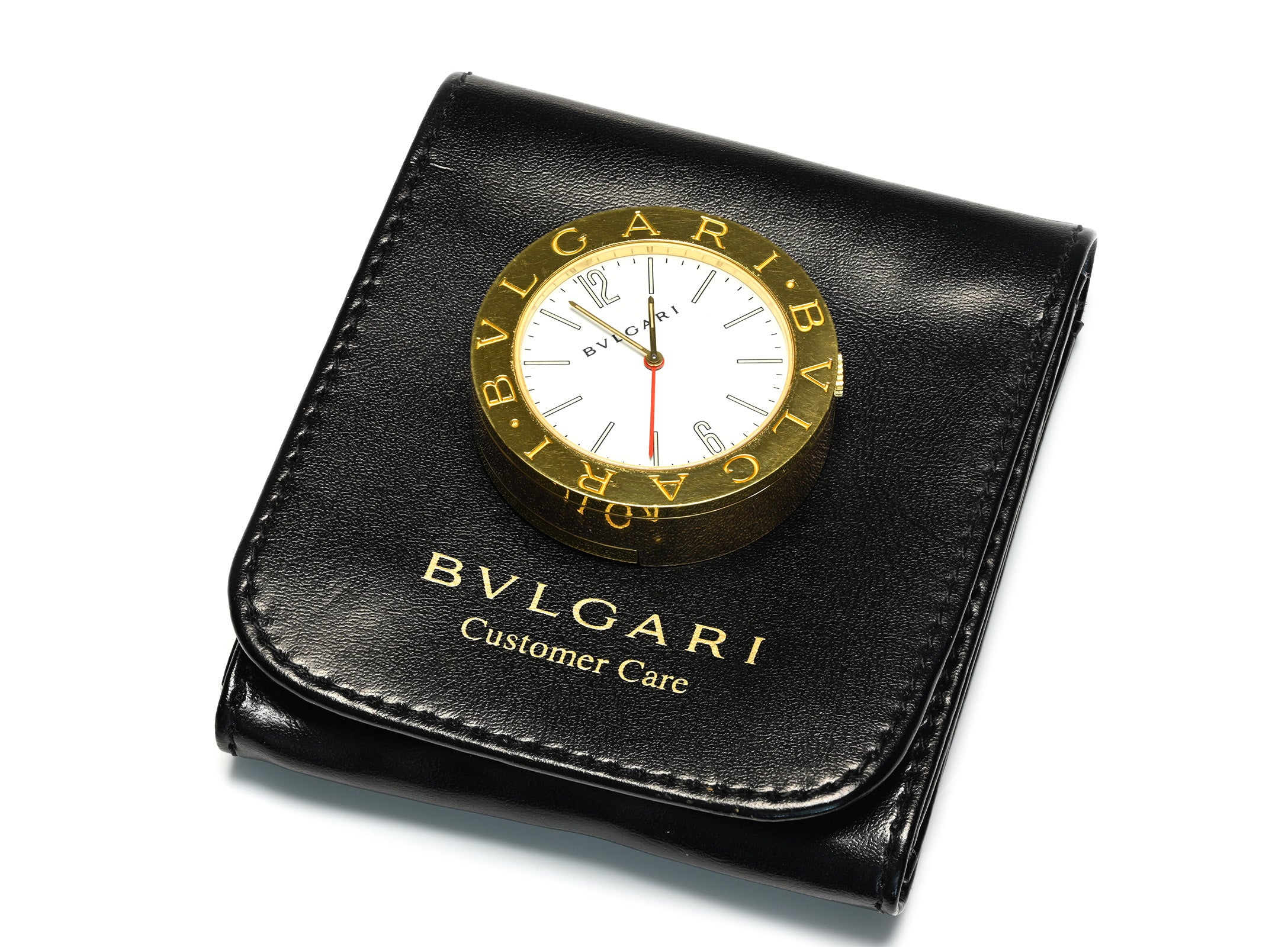 Bvlgari Customer Care watch box with an integrated round gold-tone watch face on a black leather cover, photographed on a white background.