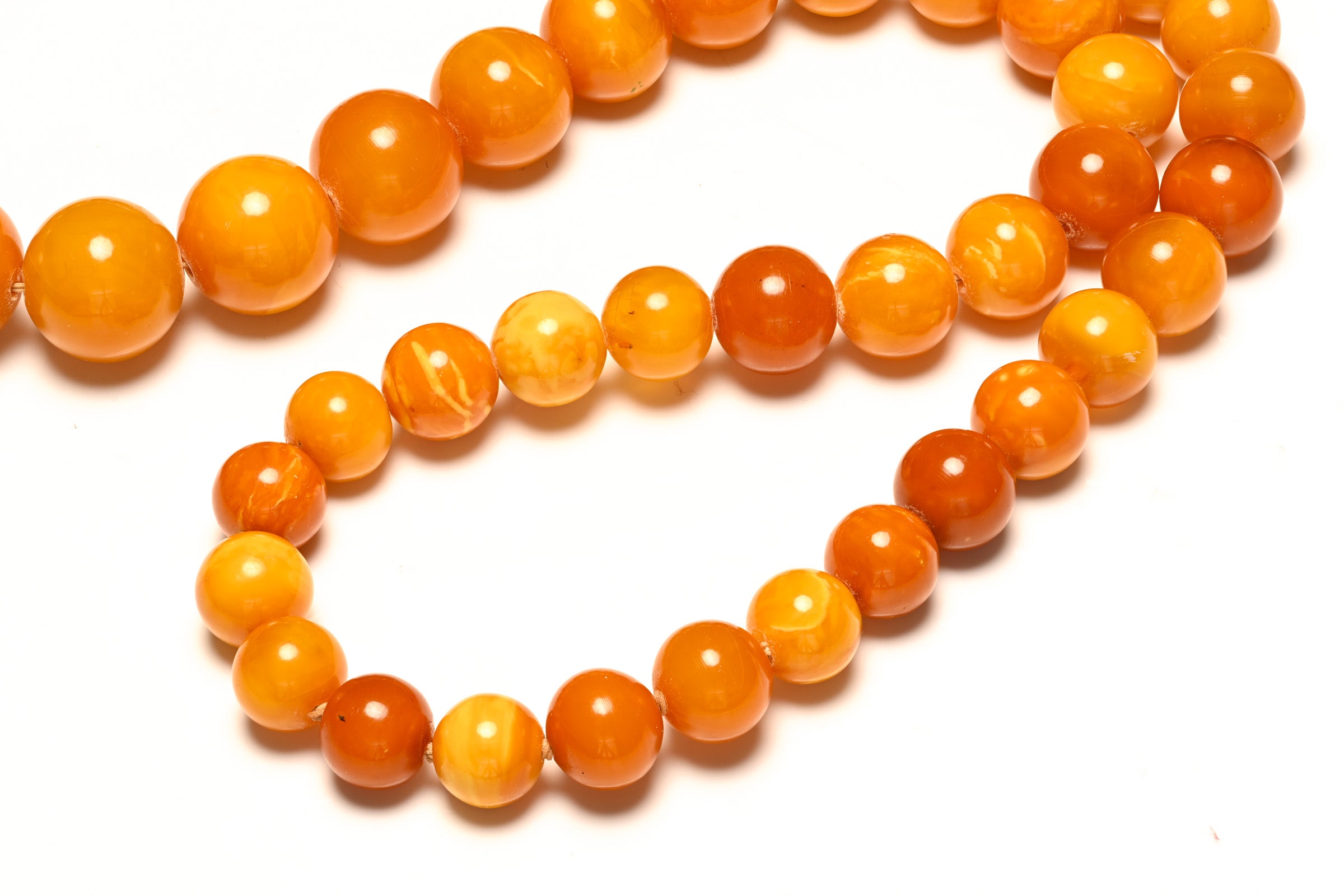 Detail view of a rare butterscotch amber bead necklace with natural amber glow.
